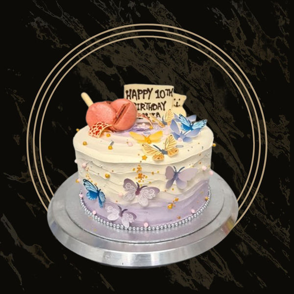 Birthday cake with chocolate drip, cream swirls, and festive toppings from The Bakers Shop in Birmingham