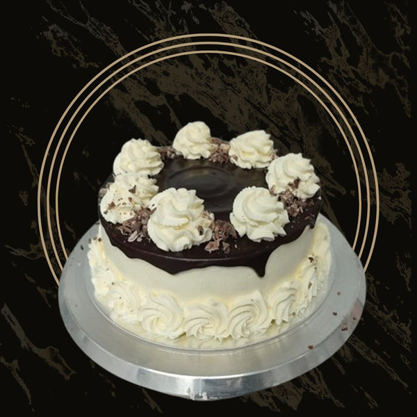 Fancy cake with chocolate decorations, gold shimmer, and piped rosettes from The Bakers Shop in Birmingham