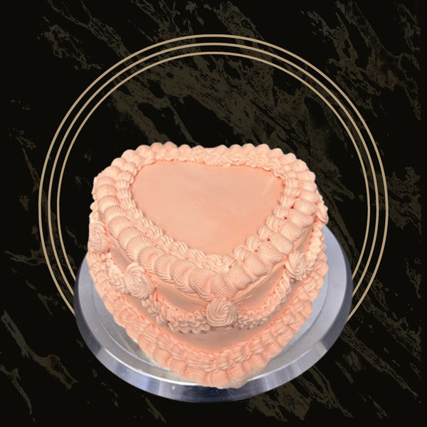 Peach Romance Heart cake with soft peach-colored frosting, elegant floral accents, and a heart-shaped design from The Bakers Shop in Birmingham