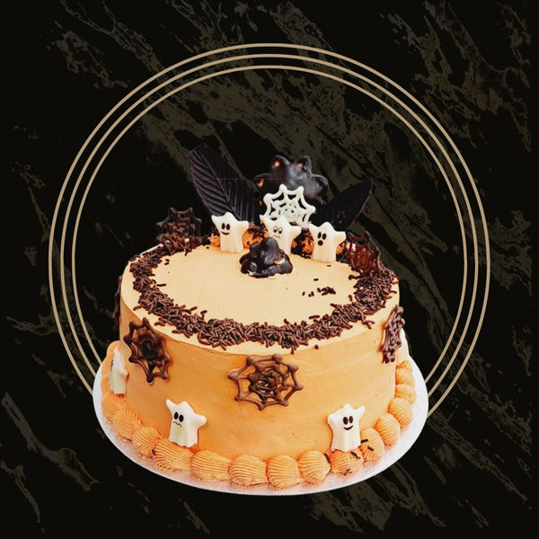 Spooky Halloween cake with ghost toppers, spiderweb design, and orange-black frosting from The Bakers Shop in Birmingham