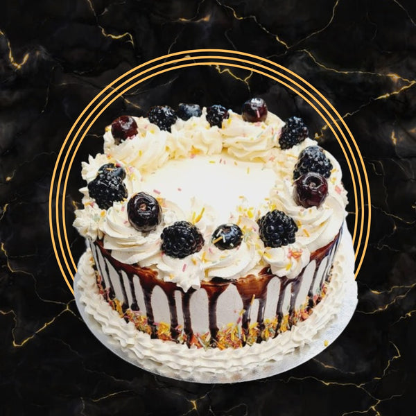 Fresh cream drip cake topped with mixed berries, chocolate drizzle, and cream swirls