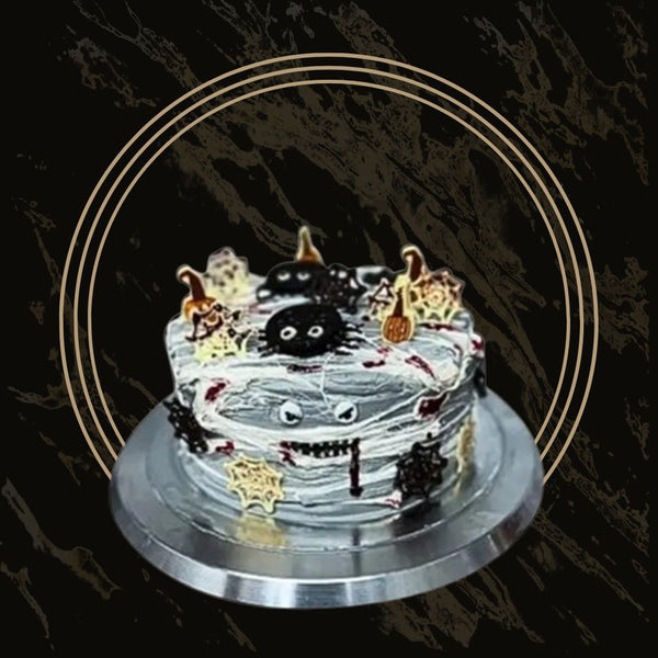 Spooky Halloween cake with black fondant, pumpkin decorations, and cobweb accents from The Bakers Shop in Birmingham